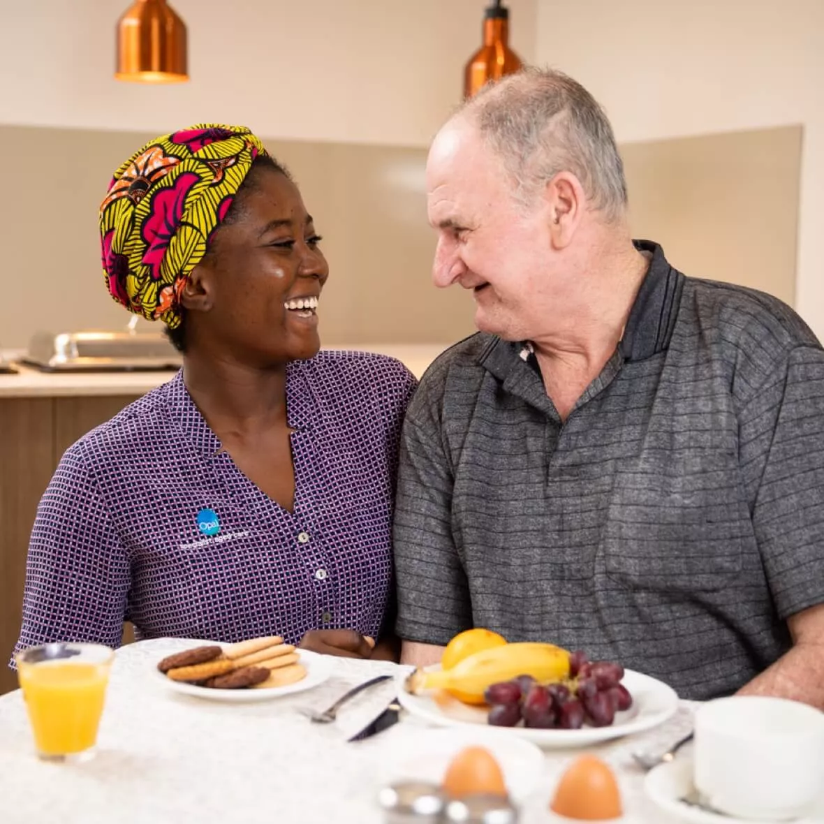 Opal Resident and team member laughing at the dinner table